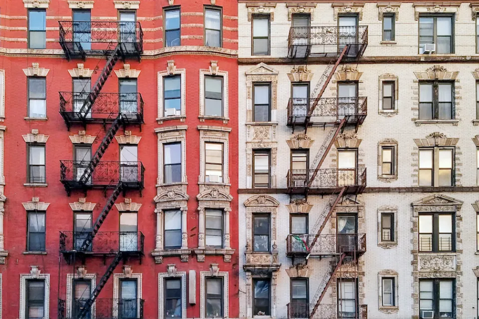 Facade of brick multistory apartment buildings in New York City with fire scapes.